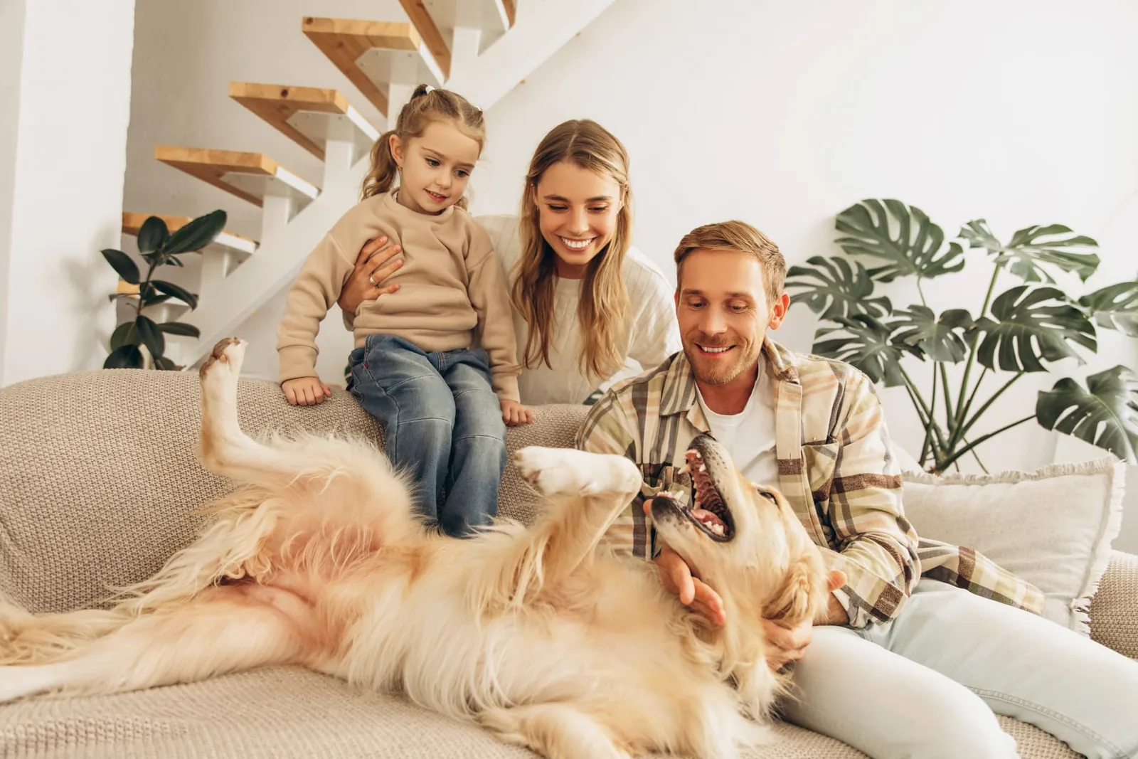 Familia compartiendo en casa con su hija y su perro